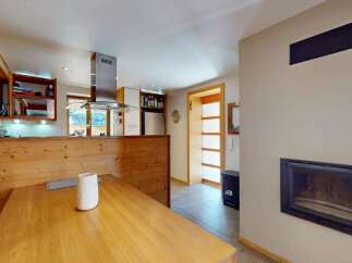 Experience cozy living in this charming kitchen and dining area, featuring a rustic wooden booth seat and a spacious dining table perfect for family meals.
