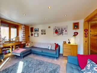 Experience cozy mountain living in this charming living room, featuring a comfortable sectional sofa perfect for relaxing after a day on the slopes.