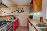 Experience rustic charm in this cozy kitchen featuring warm wooden walls and countertops.