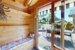 Step into this charming wooden cabin, featuring a cozy built-in bench with a festive red and white patterned cushion, perfect for relaxing after a day outdoors.