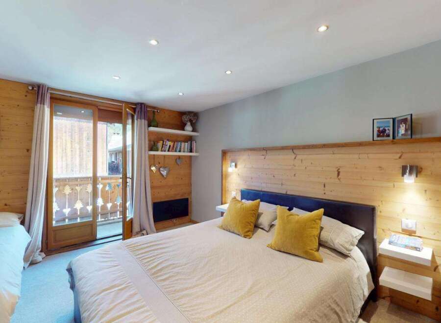 Experience cozy mountain living in this charming bedroom featuring a spacious king-sized bed with plush yellow accent pillows.