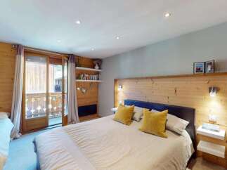 Experience cozy mountain living in this charming bedroom featuring a spacious king-sized bed with plush yellow accent pillows.