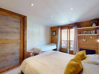This charming bedroom features a spacious master bed and a twin bed, perfect for families or guests.