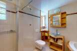 This charming bathroom features a spacious walk-in shower with glass doors and a rainfall showerhead, perfect for a relaxing experience.