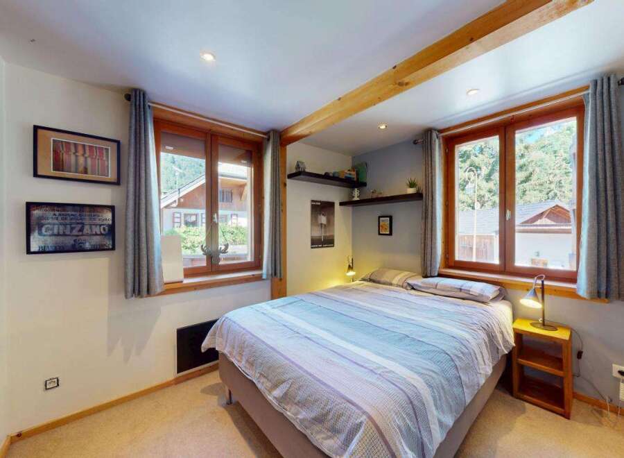 Discover this charming bedroom featuring a comfortable bed with striped linens, perfect for a cozy retreat.