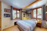 Discover this charming bedroom featuring a comfortable bed with striped linens, perfect for a cozy retreat.