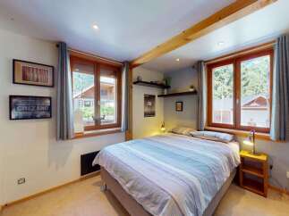 Discover this charming bedroom featuring a comfortable bed with striped linens, perfect for a cozy retreat.