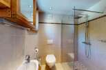 This modern bathroom features a sleek glass-enclosed shower with a rainfall showerhead, perfect for a spa-like experience.