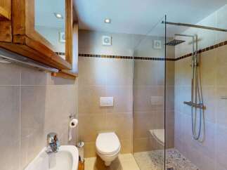 This modern bathroom features a sleek glass-enclosed shower with a rainfall showerhead, perfect for a spa-like experience.