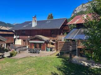 Experience mountain living in this charming wooden chalet, perfect for outdoor entertaining with its spacious deck and dining area.