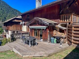 Enjoy outdoor living on this expansive wooden deck, perfect for entertaining or relaxing amidst stunning mountain views.