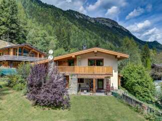 Nestled against a backdrop of lush green mountains, this charming chalet offers a serene mountain retreat.