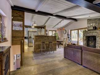 Experience rustic charm in this open-concept living space, featuring a modern kitchen with stainless steel appliances and a breakfast bar.
