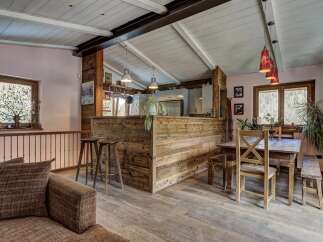 Experience rustic charm in this open-concept living space featuring a wooden kitchen island and a cozy dining area.