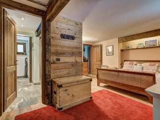 Experience rustic charm in this inviting bedroom, featuring exposed wooden beams and a cozy atmosphere.