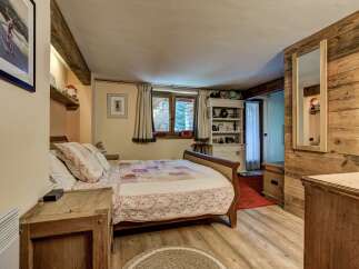 Experience rustic charm in this cozy bedroom featuring a comfortable sleigh bed adorned with a patchwork quilt.