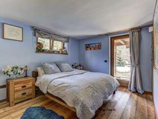 Experience cozy mountain living in this charming bedroom featuring a comfortable queen-size bed adorned with a patterned quilt.