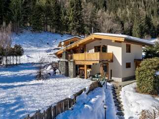 Experience the charm of this alpine retreat, nestled amidst snow-covered landscapes and surrounded by lush evergreen forests.