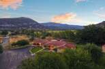 Experience serene country living with this stunning property, featuring a spacious home with a red tile roof and large windows offering breathtaking mountain views.