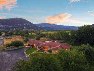 Experience serene country living with this stunning property, featuring a spacious home with a red tile roof and large windows offering breathtaking mountain views.