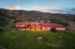 Experience breathtaking mountain views from this stunning ranch-style home, featuring a spacious covered patio perfect for entertaining and a cozy fire pit area for evening relaxation.
