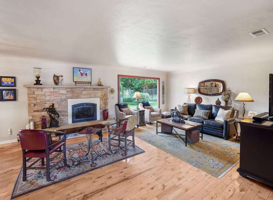 This inviting living room features a stunning stone fireplace as the focal point, perfect for cozy evenings.