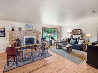 This inviting living room features a stunning stone fireplace as the focal point, perfect for cozy evenings.