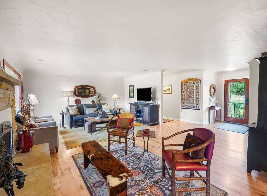 Step into this inviting living room, featuring a cozy stone fireplace and a comfortable navy blue sofa perfect for relaxation.