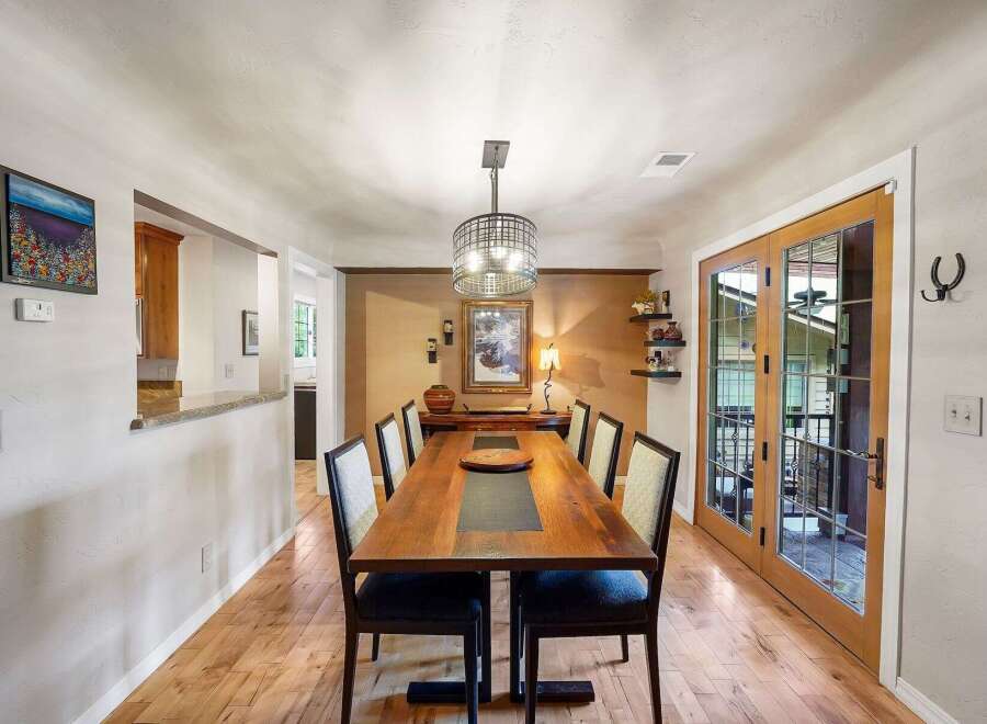 Experience elegant dining in this beautifully appointed space, featuring a substantial wooden dining table with seating for eight.