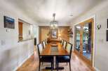 Experience elegant dining in this beautifully appointed space, featuring a substantial wooden dining table with seating for eight.