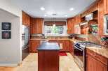 This beautifully appointed kitchen features rich cherry wood cabinetry and granite countertops, offering a warm and inviting atmosphere.