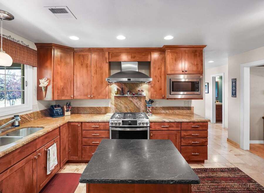 Discover this beautifully appointed kitchen featuring rich cherry wood cabinetry and elegant granite countertops.