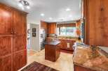 This spacious kitchen boasts rich cherry wood cabinetry, granite countertops, and a central island perfect for meal preparation.
