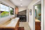 This spacious laundry room boasts a large sink and ample counter space, perfect for household chores.
