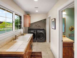 This spacious laundry room boasts a large sink and ample counter space, perfect for household chores.