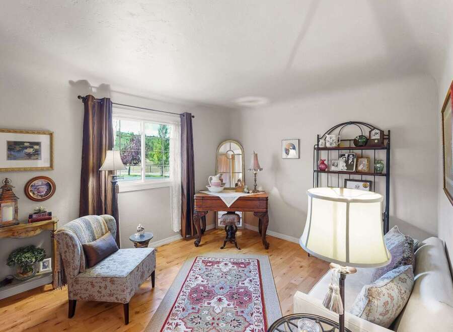 Step into this charming living space, featuring a cozy armchair and a decorative rug that adds warmth and character.