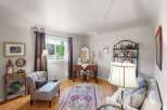 Step into this charming living space, featuring a cozy armchair and a decorative rug that adds warmth and character.