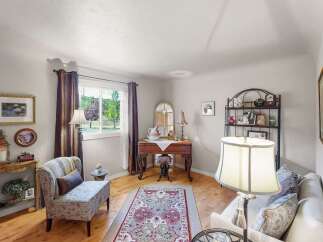 Step into this charming living space, featuring a cozy armchair and a decorative rug that adds warmth and character.