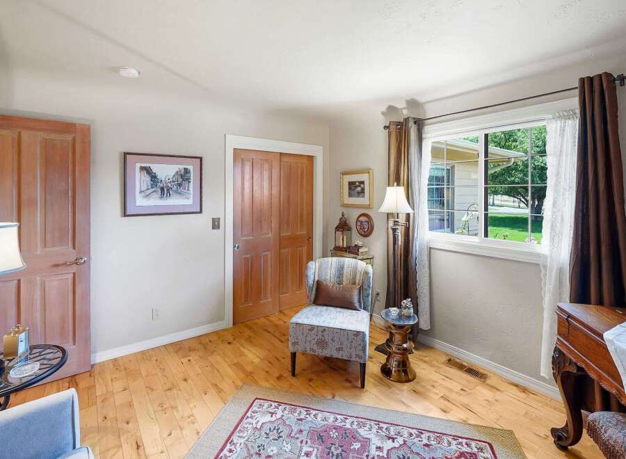 Step into this charming room featuring a cozy armchair and a decorative rug, perfect for relaxation.