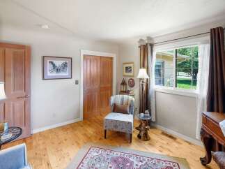 Step into this charming room featuring a cozy armchair and a decorative rug, perfect for relaxation.