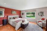 Experience serene living in this charming bedroom featuring a plush upholstered headboard and a vibrant accent wall.