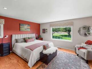 Experience serene living in this charming bedroom featuring a plush upholstered headboard and a vibrant accent wall.