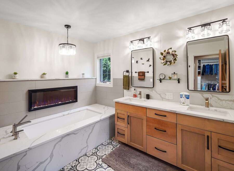 Experience ultimate relaxation in this luxurious bathroom featuring a deep soaking tub with a modern electric fireplace for a cozy ambiance.