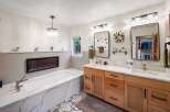 Experience ultimate relaxation in this luxurious bathroom featuring a deep soaking tub with a modern electric fireplace for a cozy ambiance.