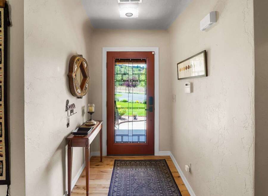 Step into this charming entryway featuring a beautiful glass-paneled door that floods the space with natural light.