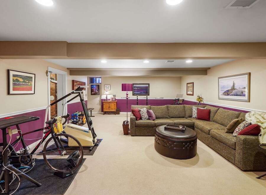 This finished basement offers a versatile space for both relaxation and fitness.