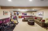 This finished basement offers a versatile space for both relaxation and fitness.