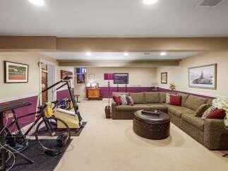 This finished basement offers a versatile space for both relaxation and fitness.