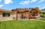 Enjoy outdoor living with this charming patio featuring a wooden pergola, perfect for al fresco dining under the sun or stars.