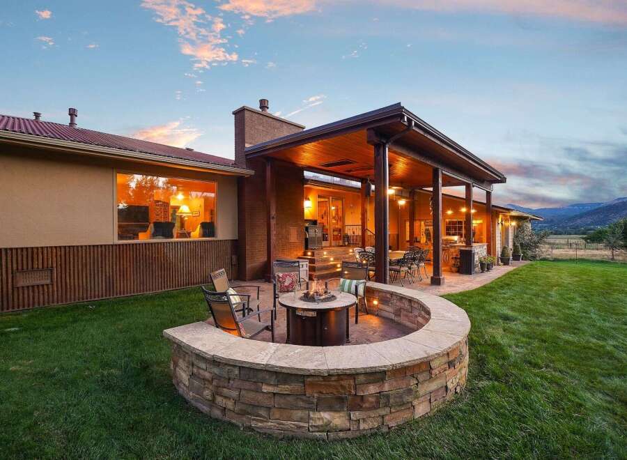 Experience ultimate outdoor living with this stunning backyard oasis, featuring a curved stone fire pit area perfect for cozy evenings.